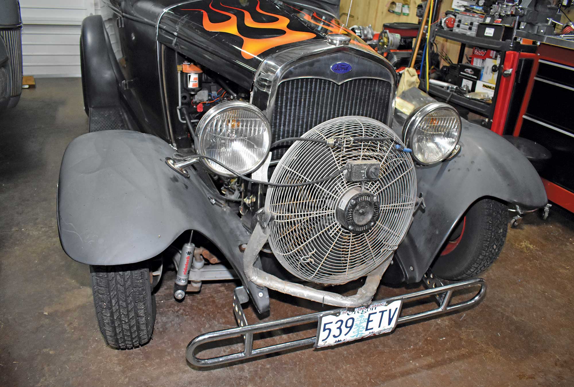 a large, effective fan displayed on a car in a garage