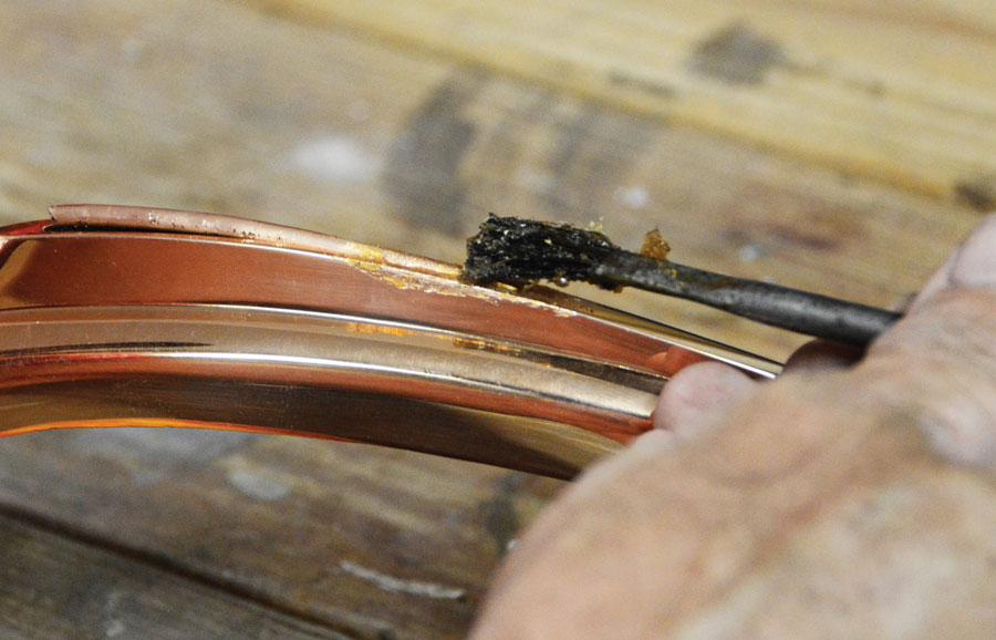11: After cleaning the copper tube with a piece of Scotch-Brite we coated the area to be soldered with flux