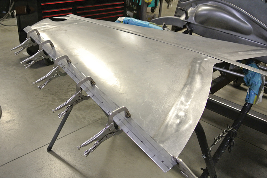 two filler strips fabricated and welded to the sides of the top hood panel