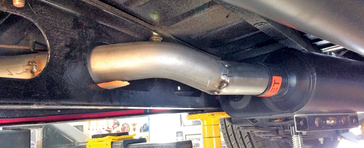 21: Tubing as it passes from the center of the car through the holes in the crossmember and into the muffler