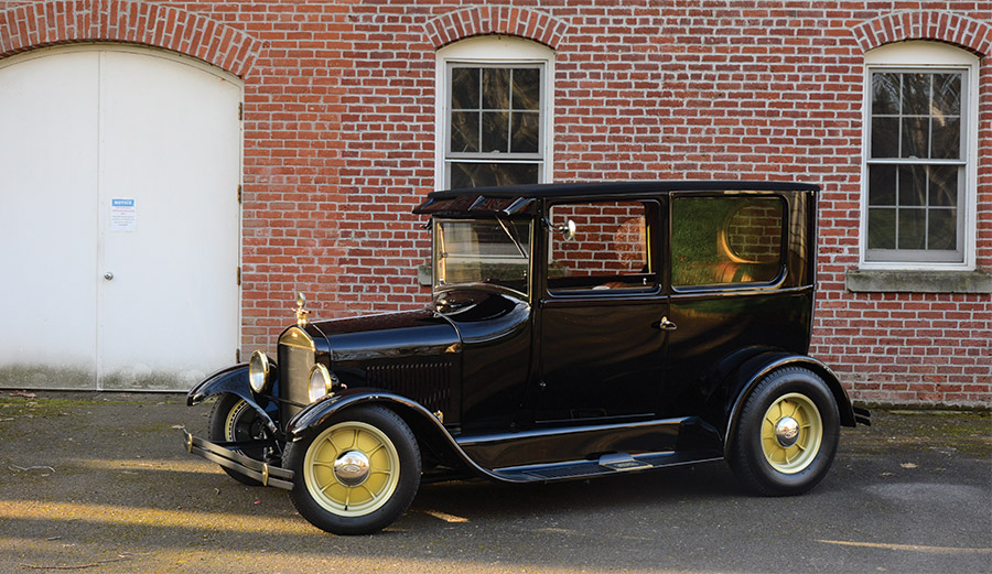 1926 Ford Tudor Sedan side profile view with brick building in background