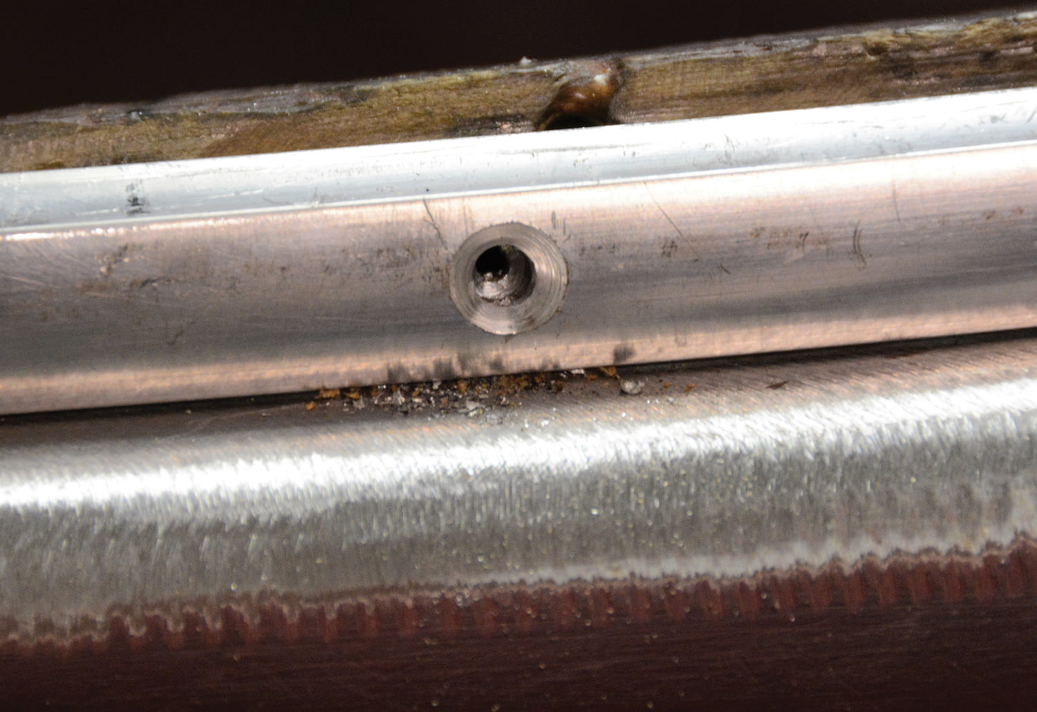 close view of a drilled and countersunk hole on the aluminum trim
