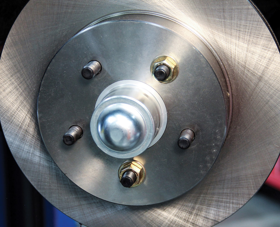 Use a pair of lug nuts (wheel nuts) to hold the rotor in place before beginning the caliper installation