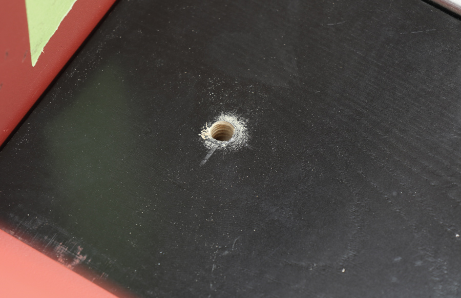 one of two holes that are drilled into two of the wooden planks