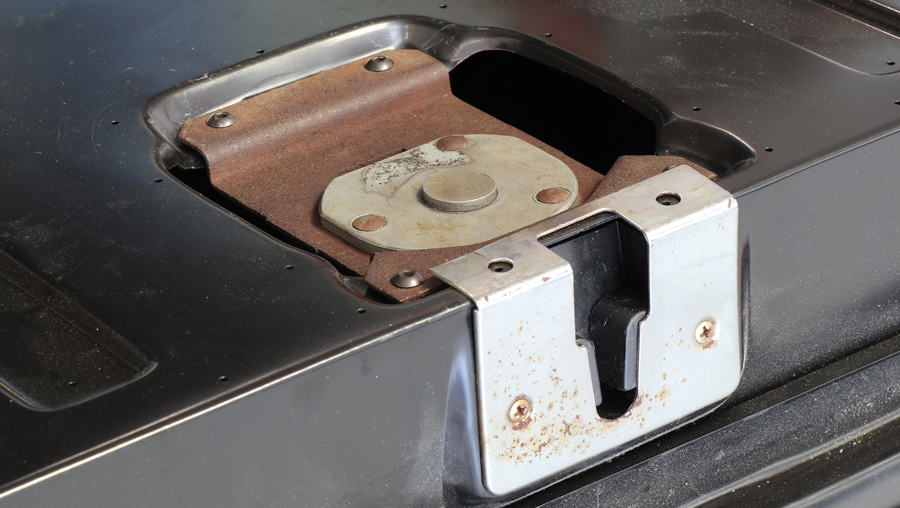 Not seen but the Danchuk handle to latch rods (PN 15539) run within attaching to the center-mounted handle and then outward to the latch mechanisms. Also supplied is the Danchuk striker cover (PN 16832) for the tailgate handle latch.