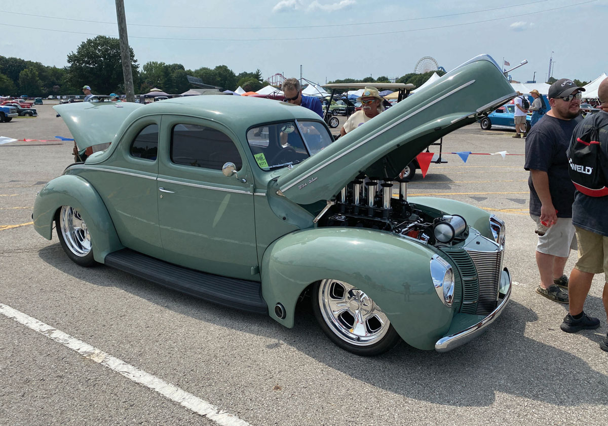 Light green classic hot rod with open hood and trunk