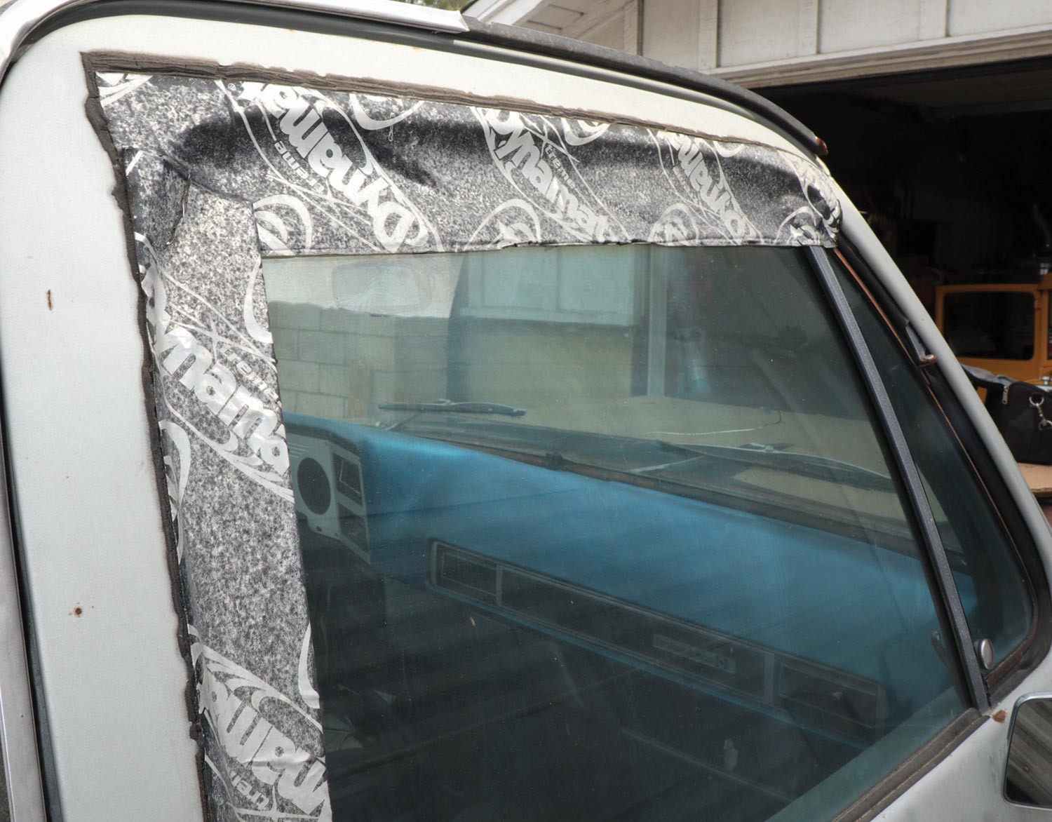 view of faded Dynamat Xtreme, once applied to a separate car window to keep rain water from seeping in