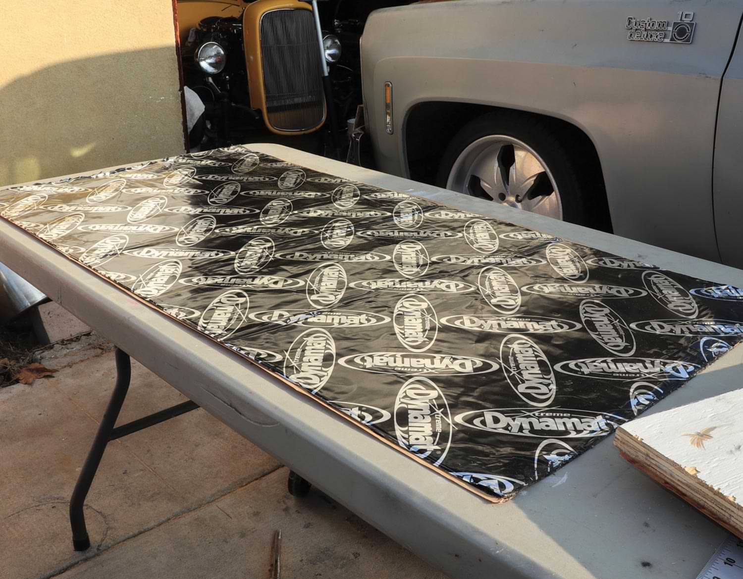 a table holds sheets of Dynamat Xtreme in preparation for installation