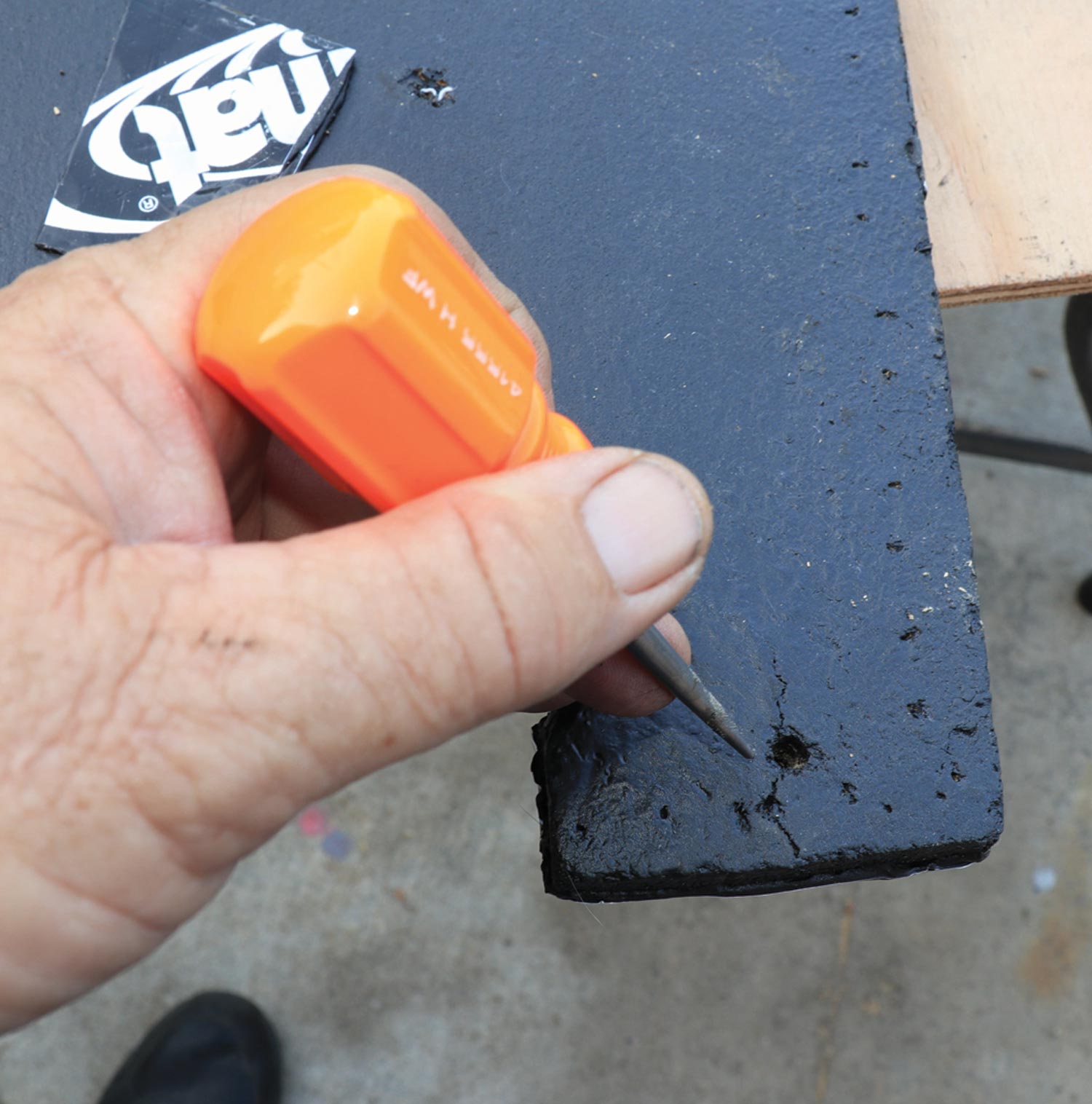 a scratch awl is used to punch out the mounting holes beneath the Dynamat sheet