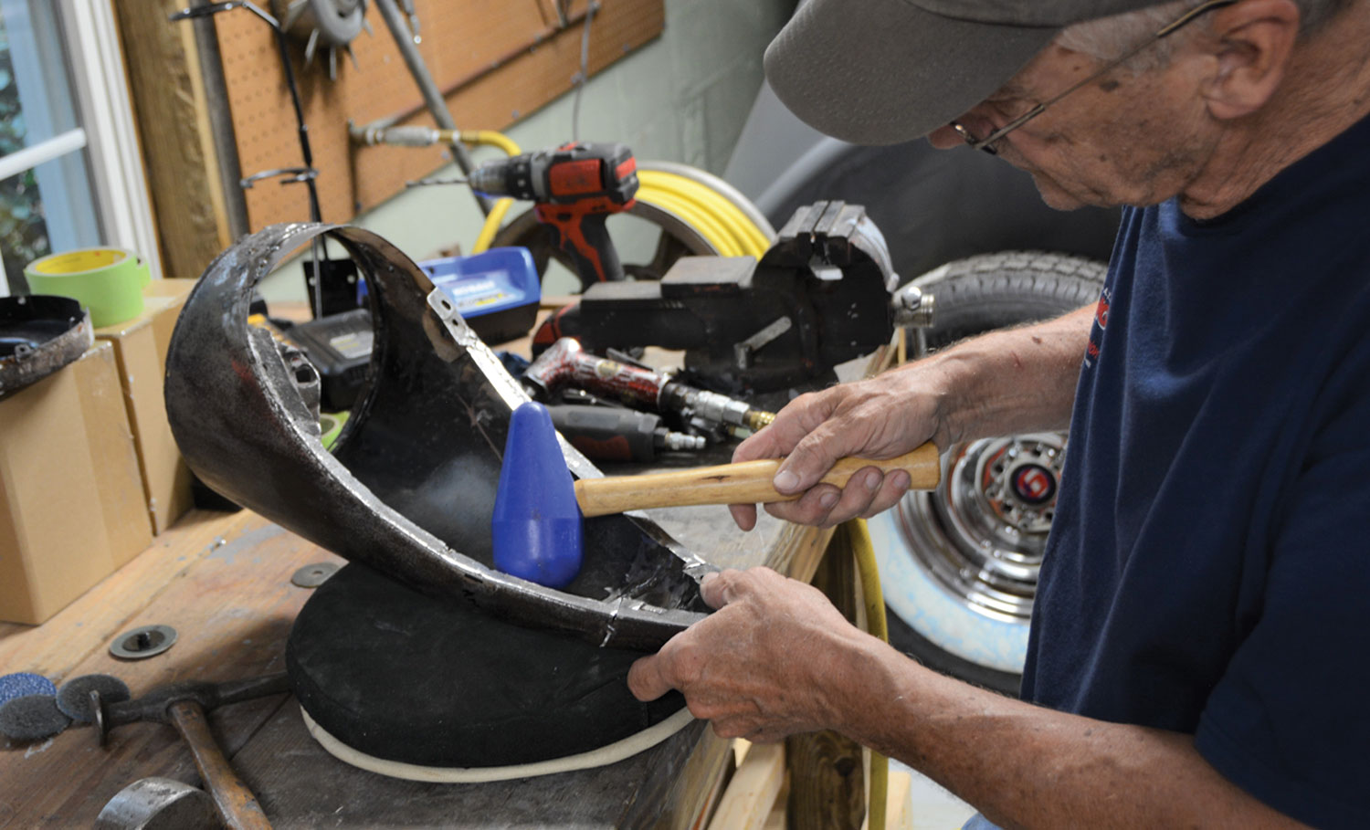 mechanic gently adjusts the rear cuts with a rounded rubber hammer