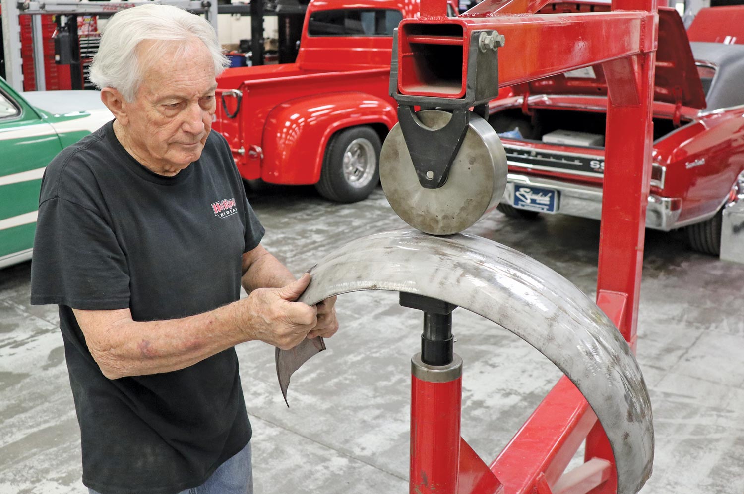 mechanic Ron McCorkle uses an english wheel to stretch the edges of the tire cover, opening the contour
