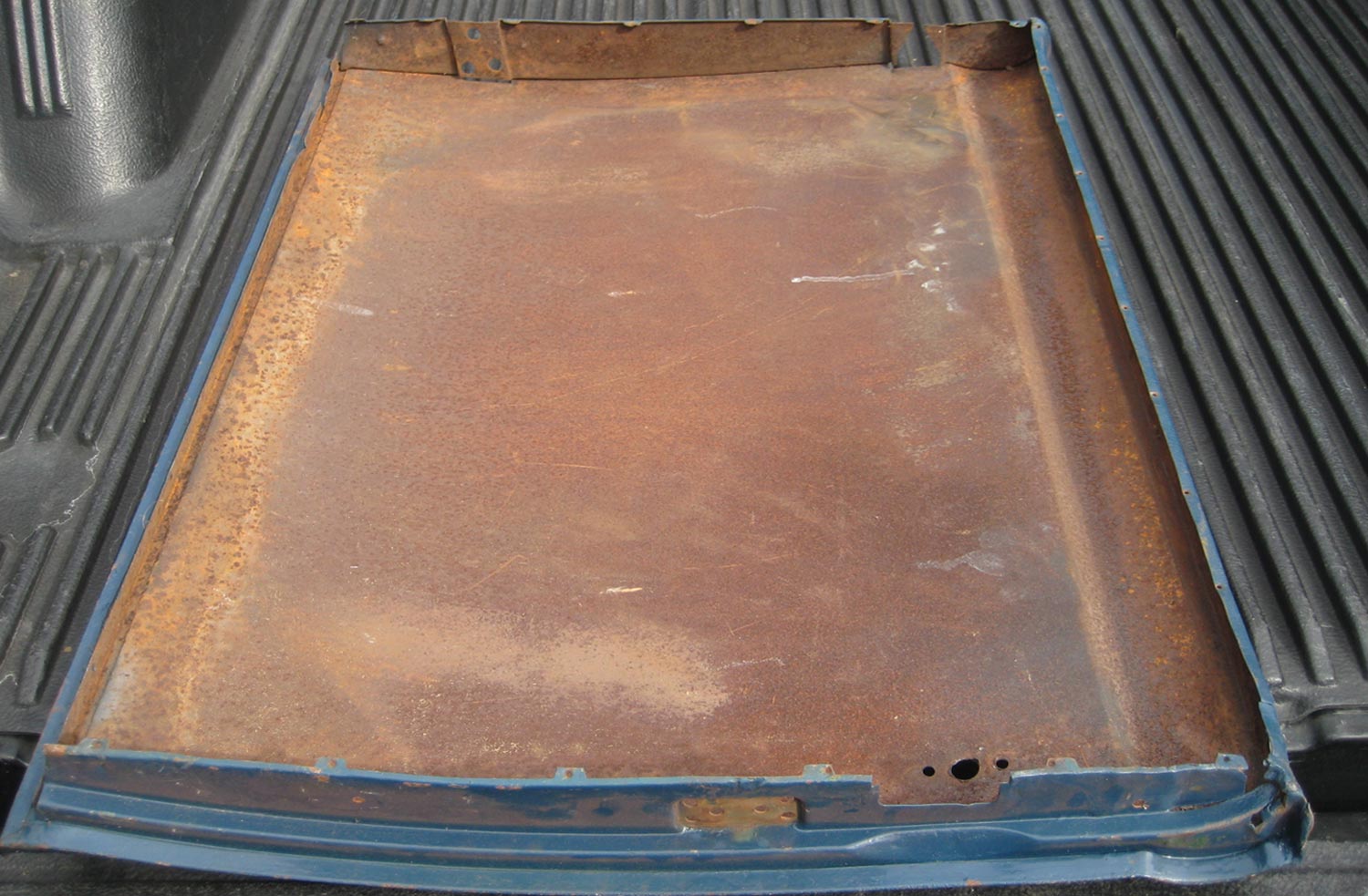 inside view of the driver side door showing a coat of surface rust