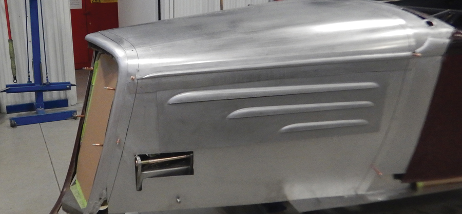A section from the old hood sides containing the vents is test-fitted to the new hood side.