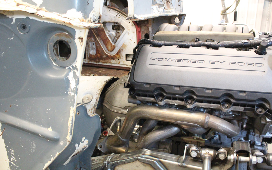 The engine sits back roughly 2 inches from the seam where the original firewall joined the cowl. Despite the recess all the engine components, such as the intake manifold and cam covers, can be removed with the engine in place. 