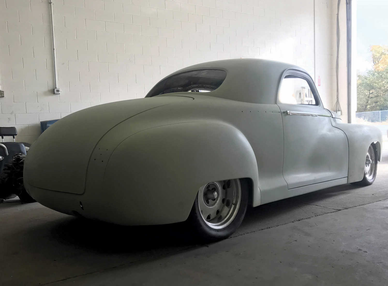 three quarter back view of Doug Melson’s ’47 Dodge parked in a garage, front toward the door