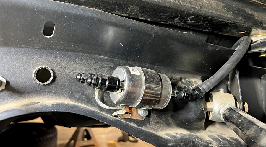 The CPP-provided external fuel pump/regulator affixes to the frame. Remember to also drill a pilot hole so that the tang on the bracket can locate within the drilled hole, thus preventing the filter/regulator bracket from moving. 