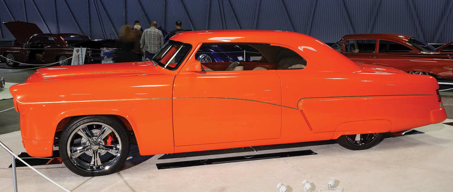 drivers side view of a vibrant orange ’54 Merc