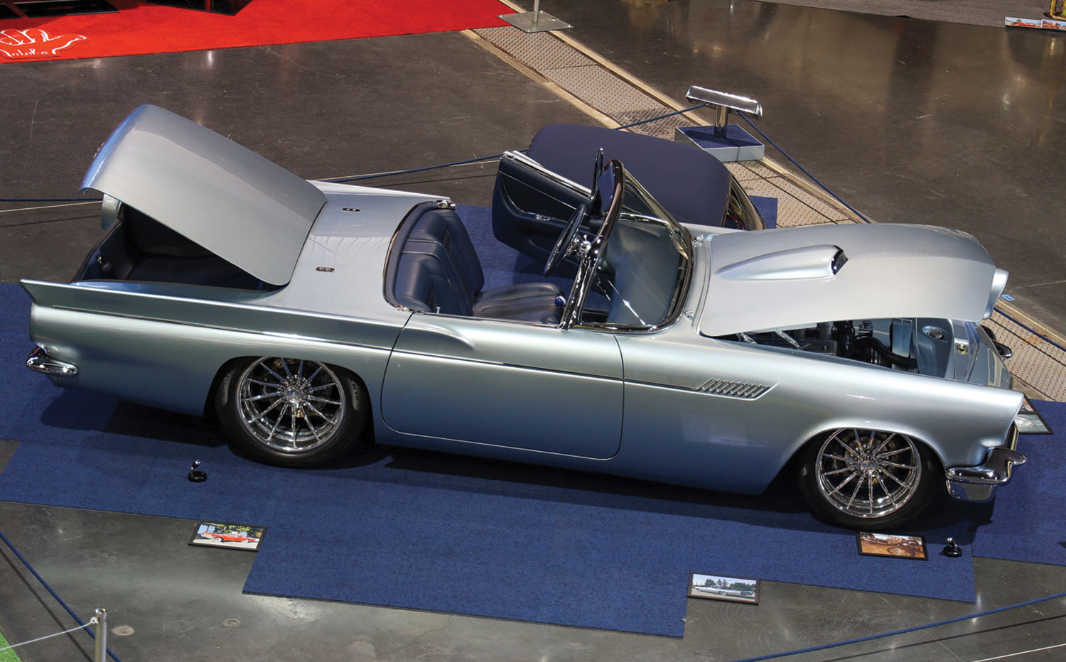 high angle passenger side view of a silver ’57 T-bird with its top removed and hood and trunk open