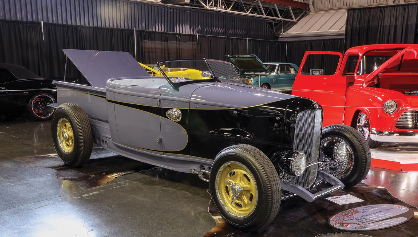 three quarter front view of a grey and black ’32 Ford roadster pickup with yellow trim