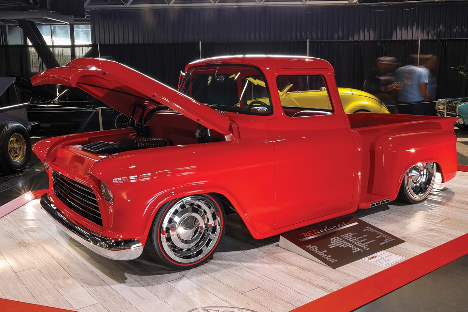three quarter front view of a fire engine red ’56 Chevy pickup