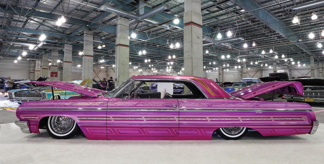 drivers side profile view of a vibrant purple pink ’64 Chevy Impala with unique patterned paint work