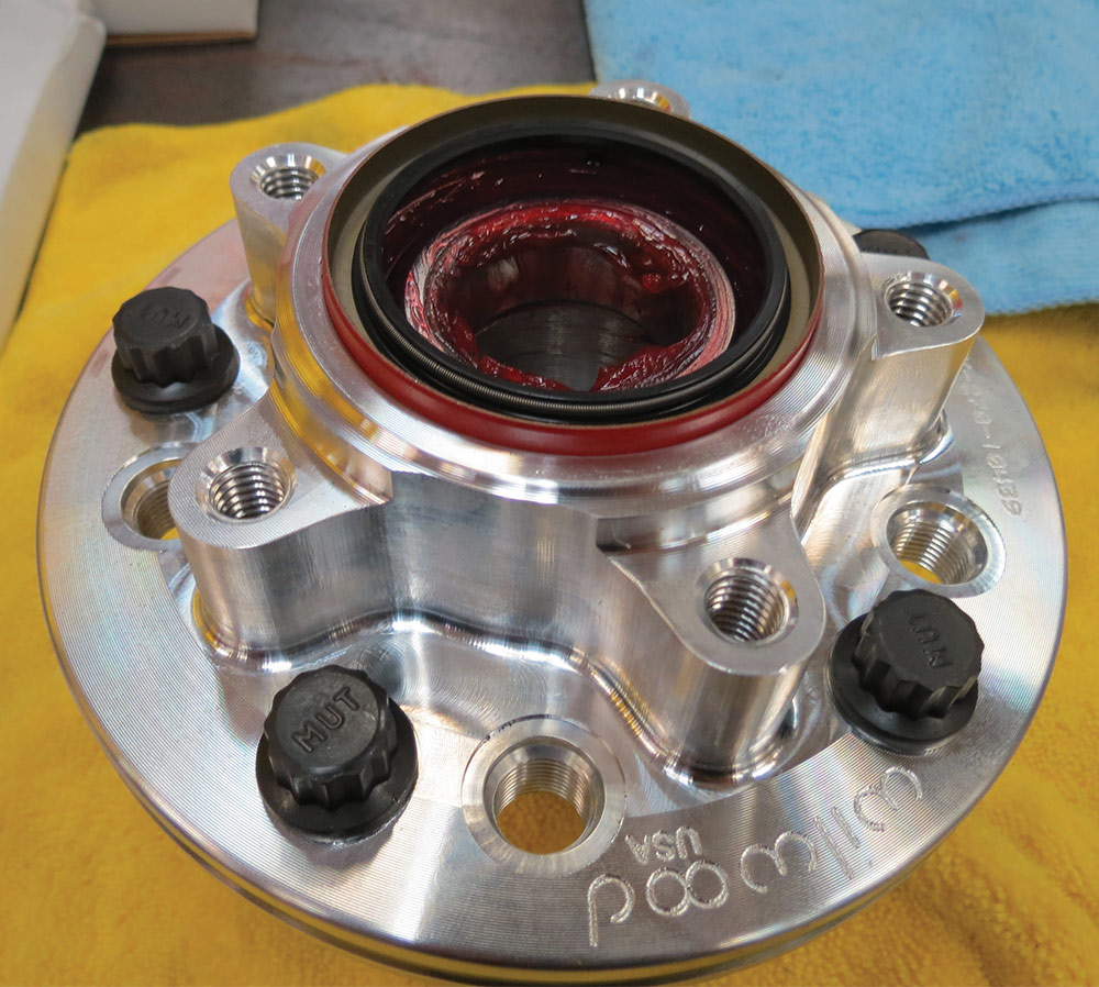 Threading wheel studs and greasing wheel bearings in brake hub