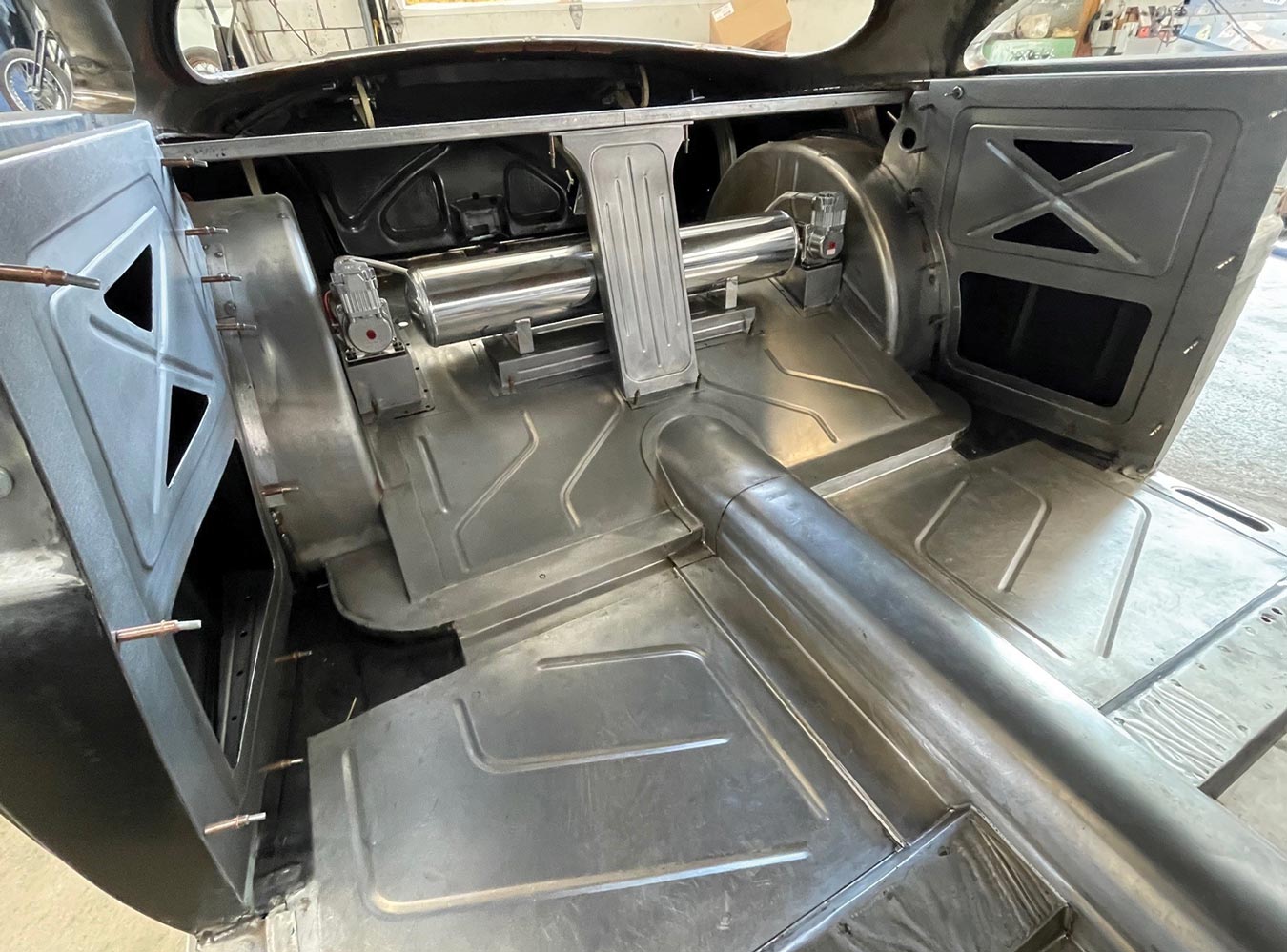 view of the back seat area with the strong brace for the package shelf in place along with the mounts for the air tank for the Ridetech suspension
