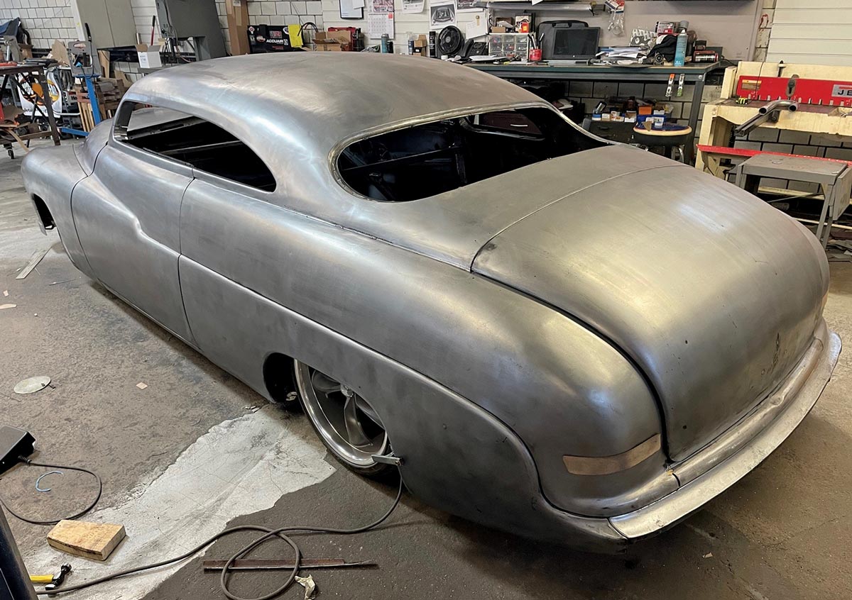 three quarter rear view shot of the metal-finished ’50 Merc parked in a garage