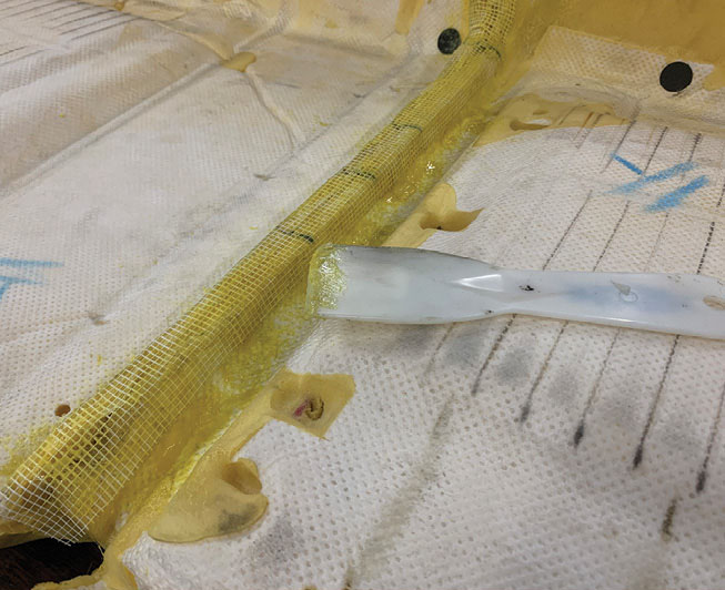To force the adhesive into the mesh tape, Winter uses a plastic spatula. Here he joined the two sections of the HHR split back seat foam into one.