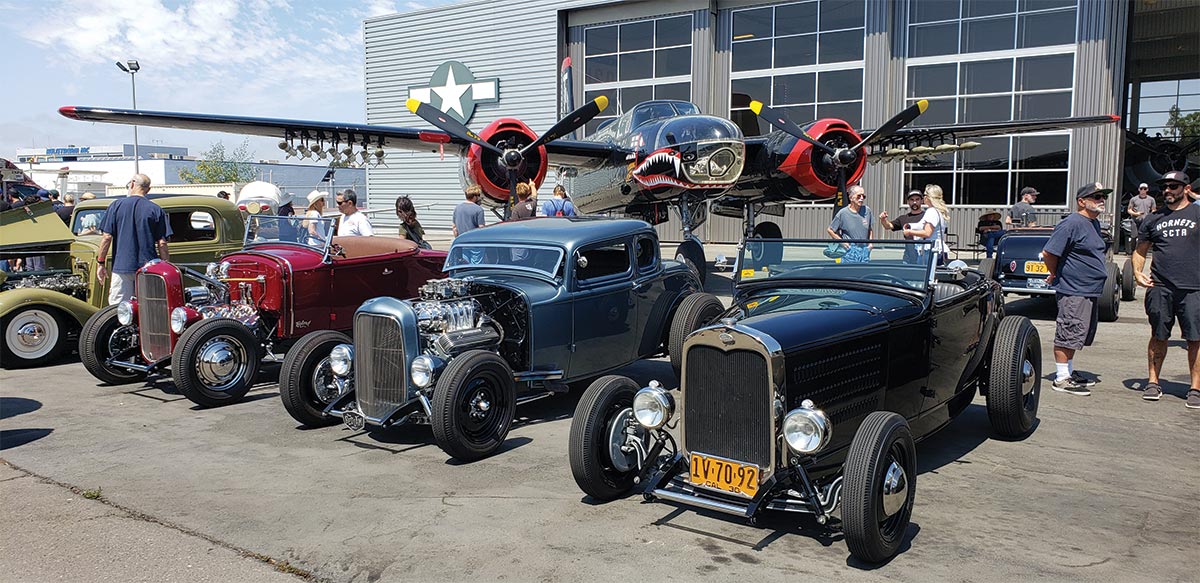 Various Model A coupes in front of A-26 Invader