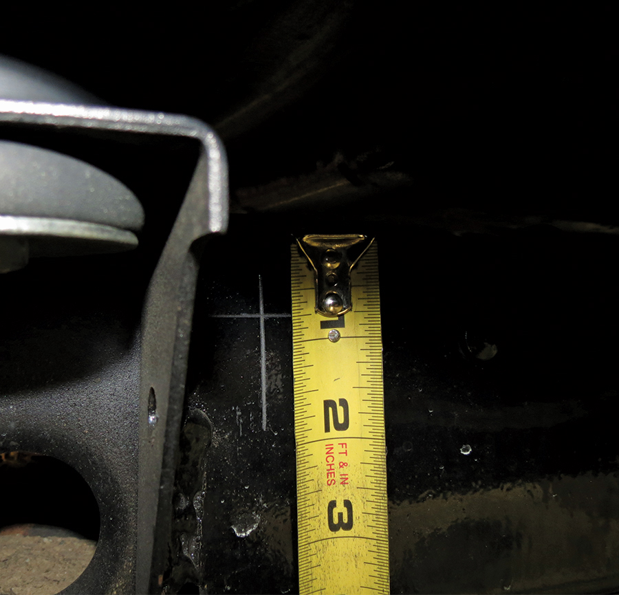A picture of a measuring tape measuring a car suspension