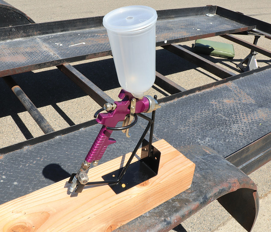 Gravity-feed HVLP spray gun set on a block of wood