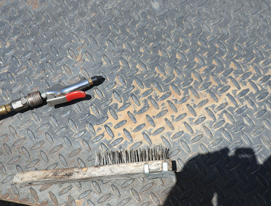 Stiff wire brush and air pressure nozzle on Model A frame