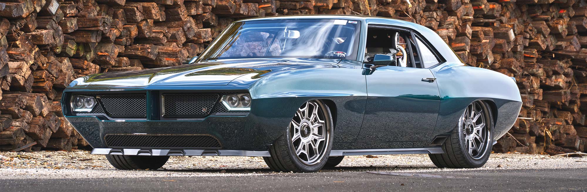 Front left 3/4 view of Firebird in front of lumber pile