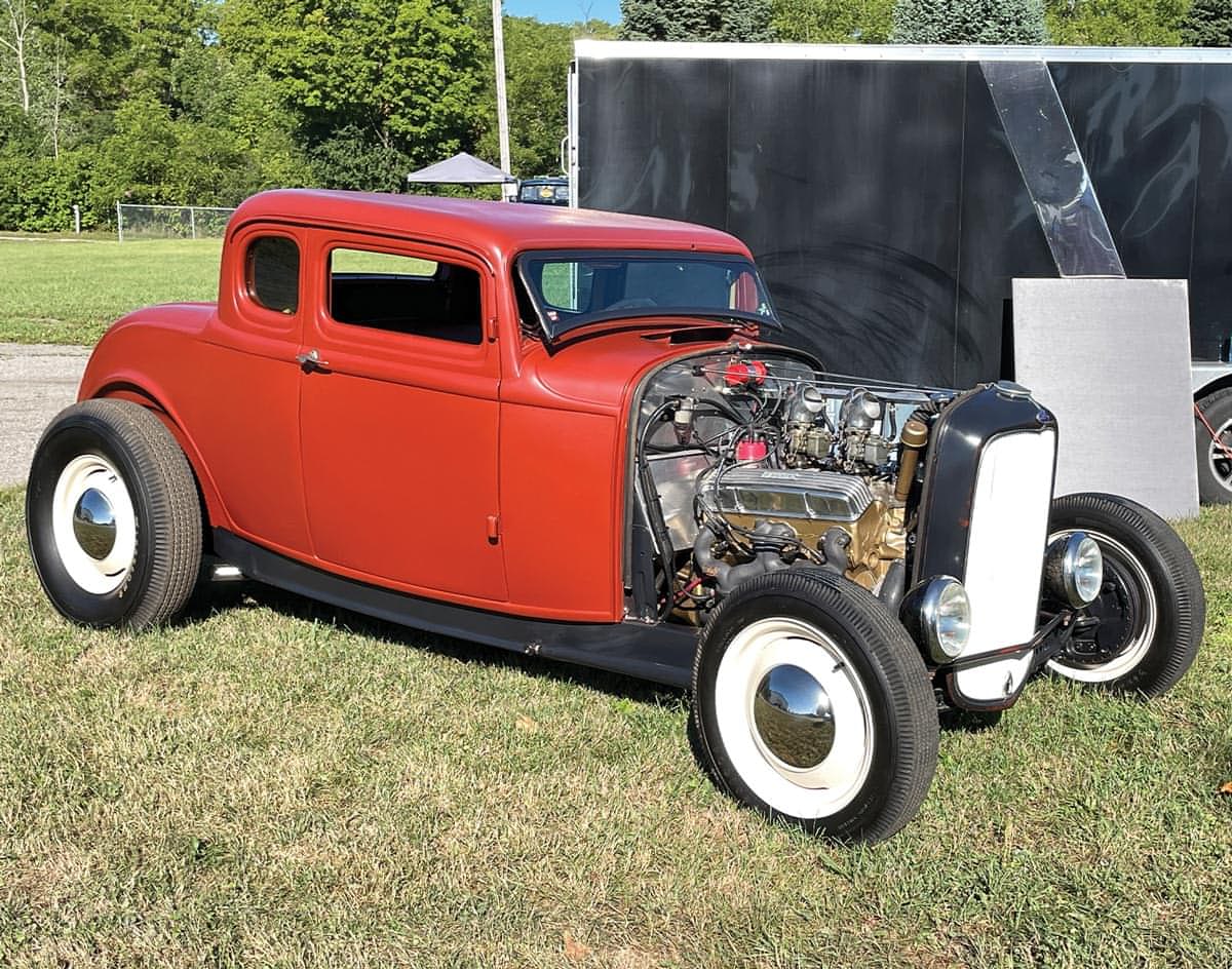 a burnt orange ’32 Ford coupe with the hood removed