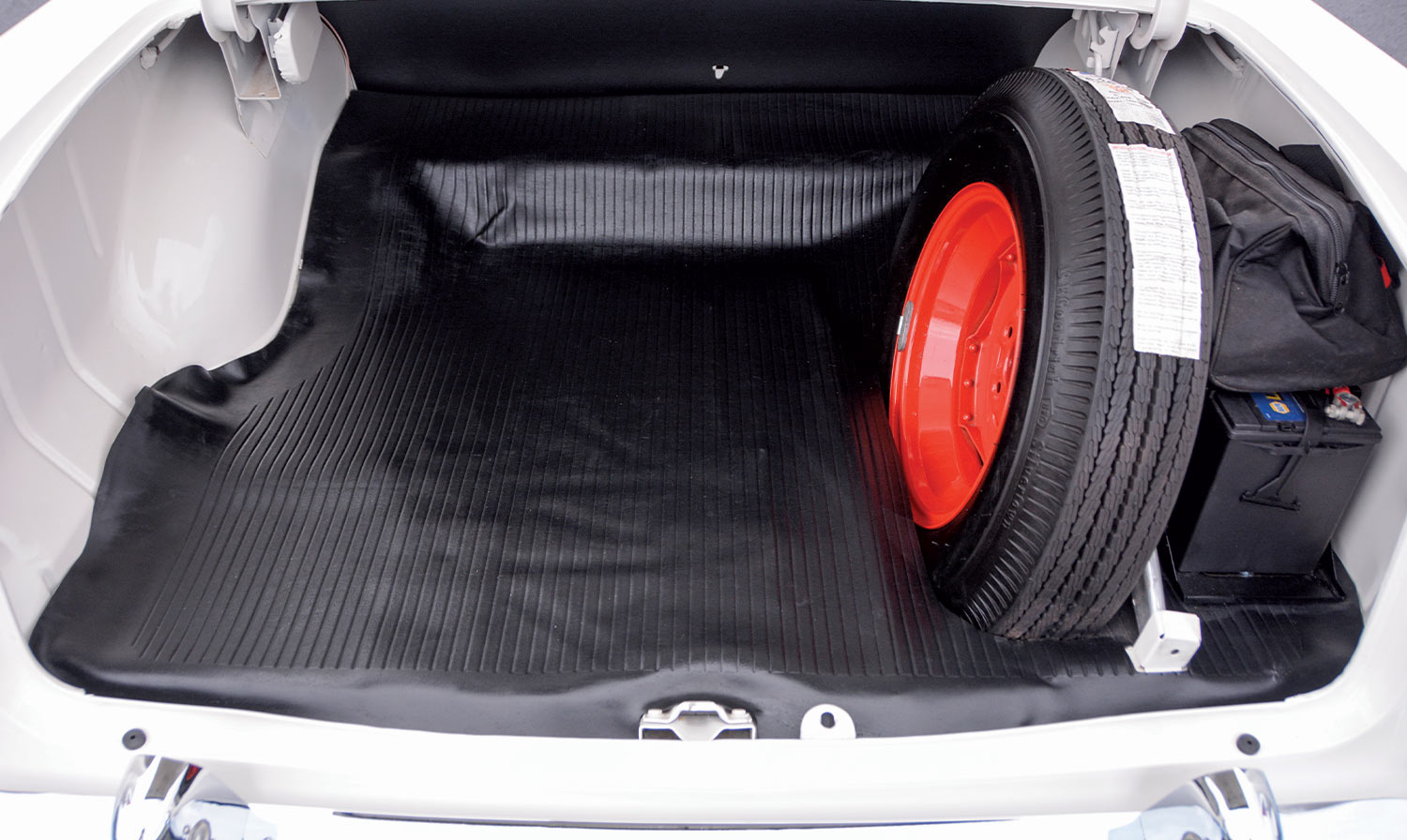 view inside the ’55 Chevy Delray's boot that holds a spare tire a supply bag and a spare battery
