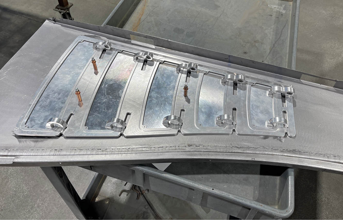 machined aluminum components following the contours of the hood side