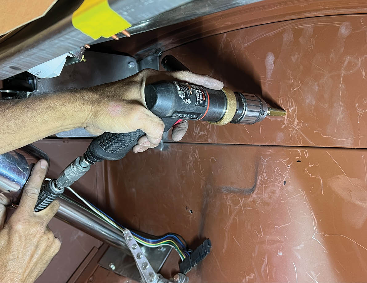 Jones used a step-drill bit to make the firewall holes for the mounting bracket.