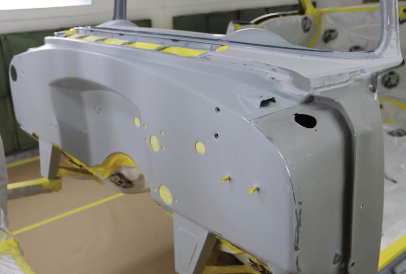 Here at MetalWorks the ’55 Chevy began with an entirely stripped body shell, so no need for bagging. Instead, he masked off every penetration through the firewall.