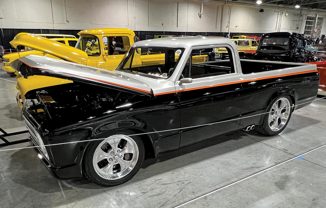 three quarter drivers side view of a ’59 Ford F-100 with a silver and black block paint job separated by an orange stroke