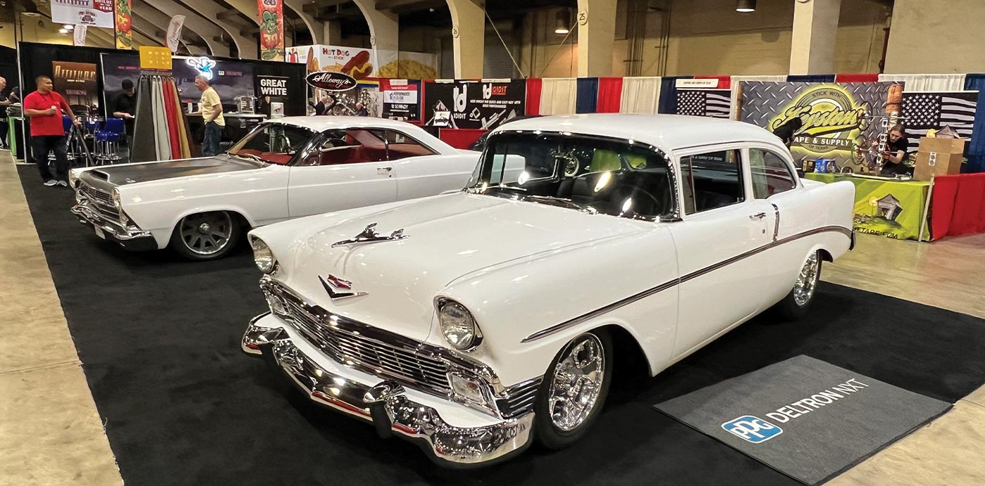 wide view of a white ’56 Chevy and a white Fairlane parked side by side