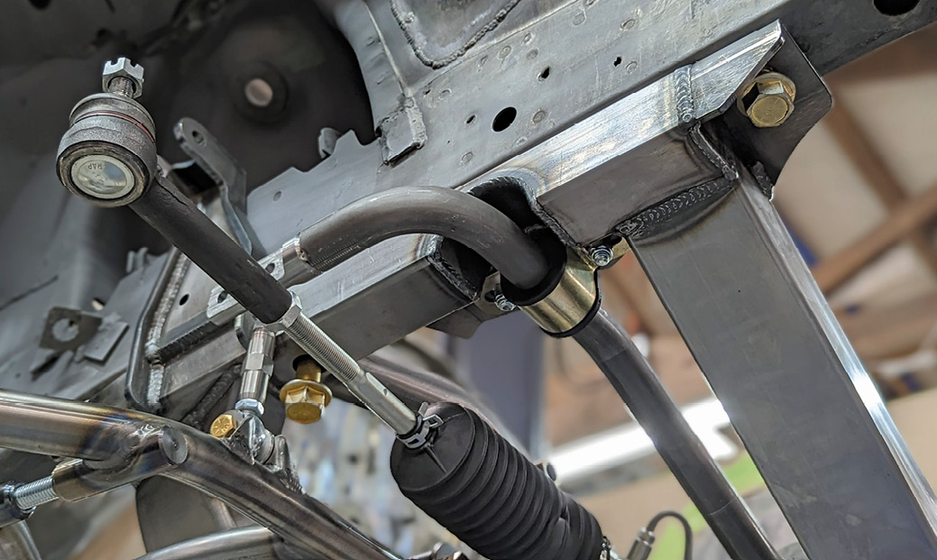 To keep the car flat when cornering, an antiroll bar is part of the suspension package. Note the three holes in the attachment link that provides suspension “tuning.”