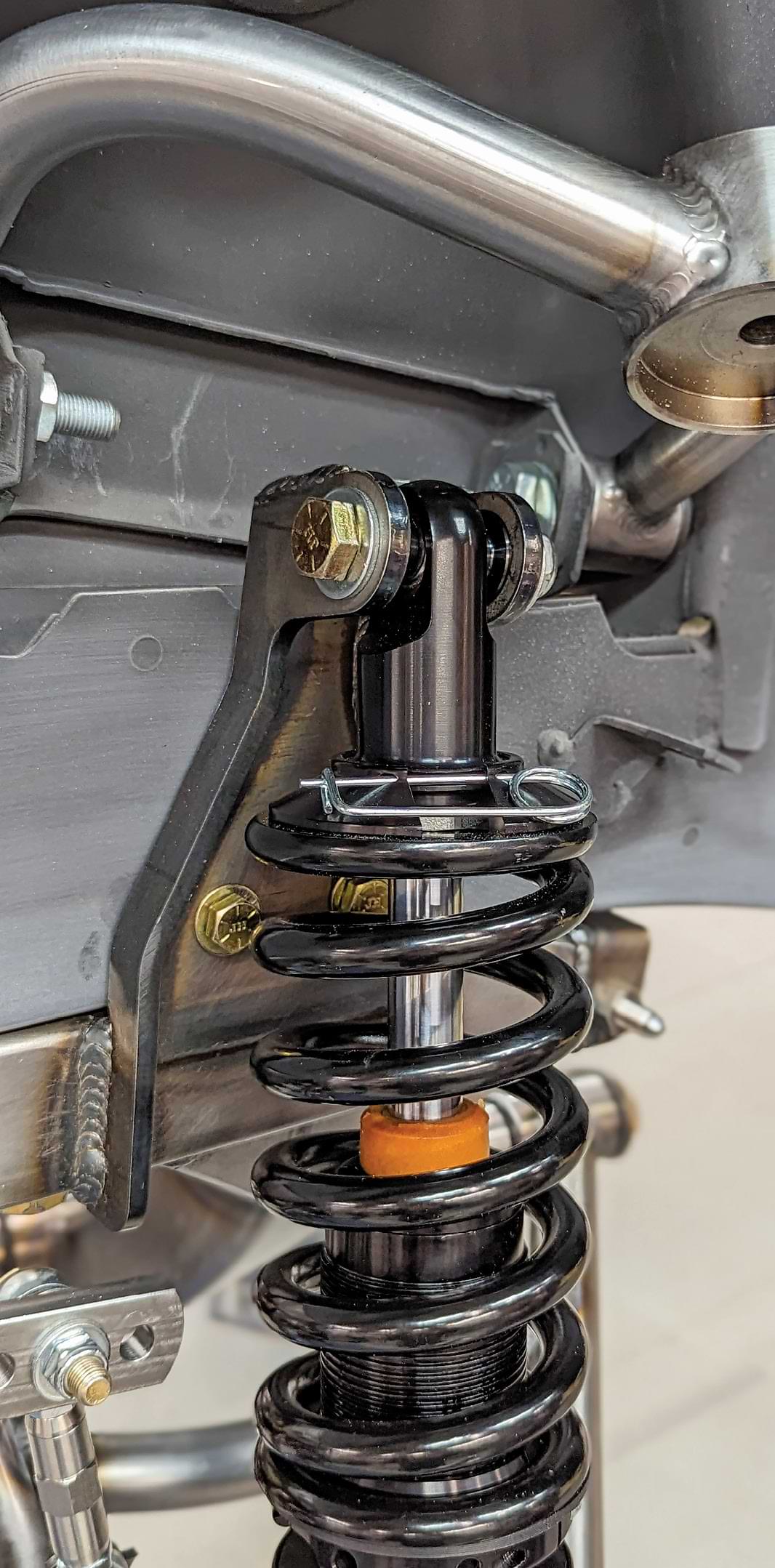 The Strange Engineering coilovers are installed using the supplied hardware. Spacers are used to properly position the coilover in the upper bracket.
