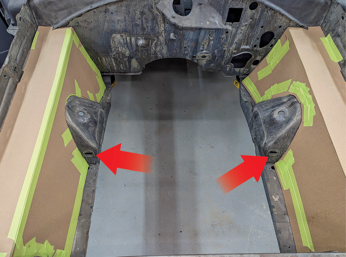 Note the two holes in the front of the shock towers (arrows) for the front caster/camber eccentrics. No modifications are necessary to the inner front fenders; the cardboard templates are for smooth panels that Horsepower Northwest will be fabricating.