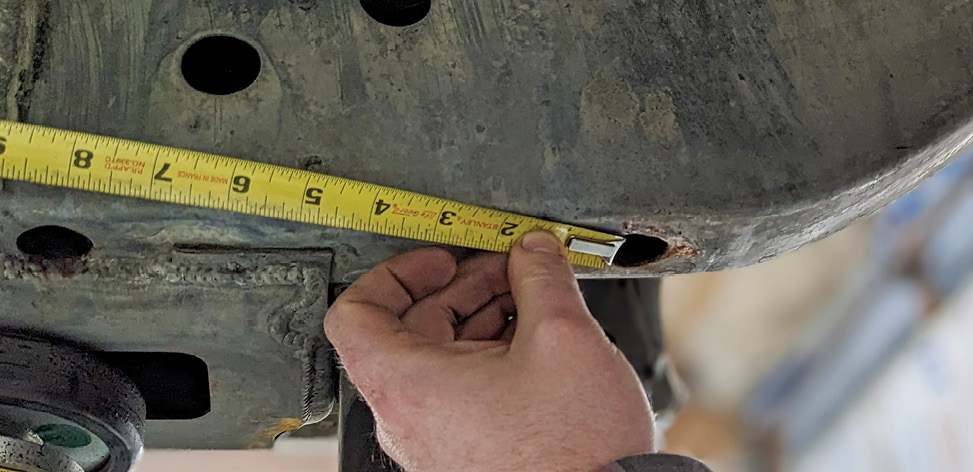 To ensure the unit is square to the car, measurements are taken from the factory datum hole in the rear framerail diagonally to a lower control arm grease zerk fitting. (Datum: For example, on a car’s wheel, the lug nut holes define a bolt circle that is a datum from which the location of the rim can be defined and measured.)