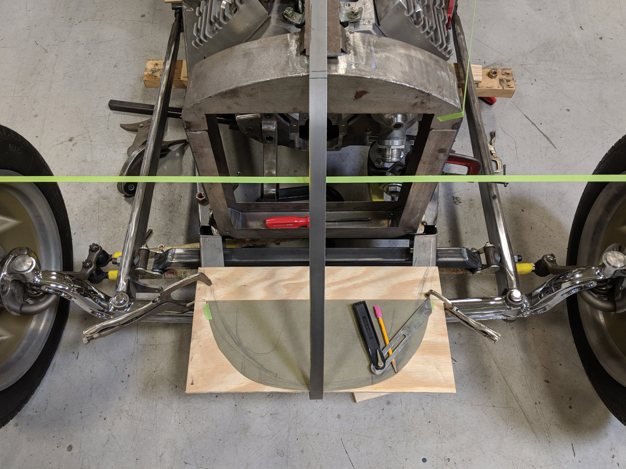 The first step in making a track nose is to start with the known dimensions. Here the radiator is mocked-up and a strip of steel is being bent to check the desired profile