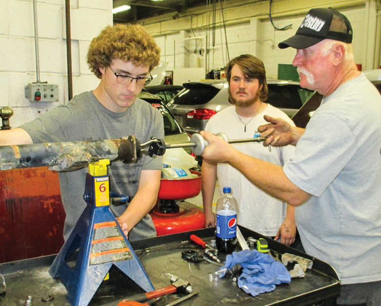 Axles and bearings will be replaced as necessary. Here Mr. Greene demonstrates seal removal. Youngsters Tharen and Zach get it, so they’ll pull the opposite-side seal. 