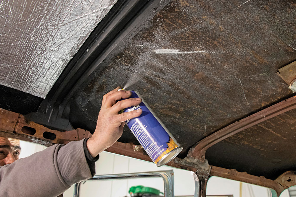 Spraying interior roof with adhesive