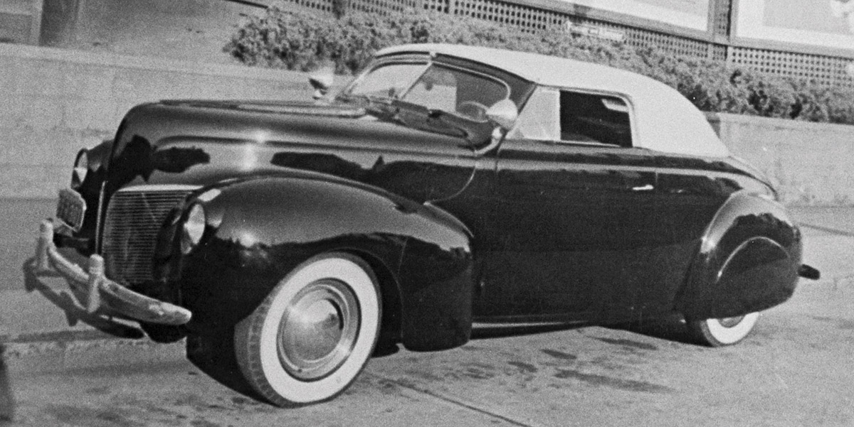 Black & white photograph of Tommy’s Merc, front profile, taken in San Francisco (Life With Father film billboard indicates 1947). Early speed equipment on the Merc’s Flathead included McCollough blower and Federal-Mogul high-compression heads.