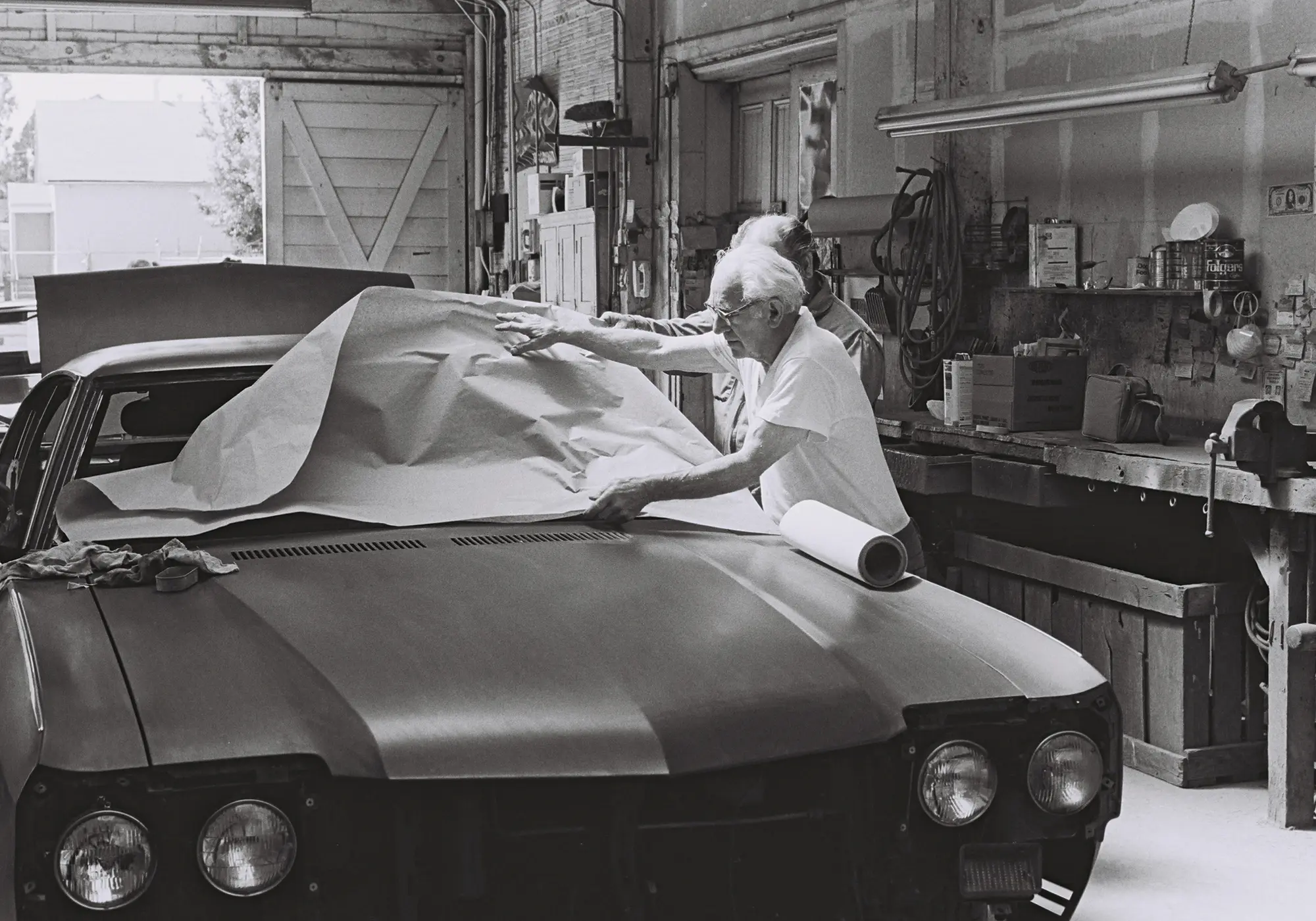 Tommy in his shop masking off the windshield opening on a car before painting